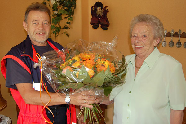 Volker Wirths von den Johannitern berreicht der 750. Teilnehmerin Inge Thiel einen Blumenstrau.
