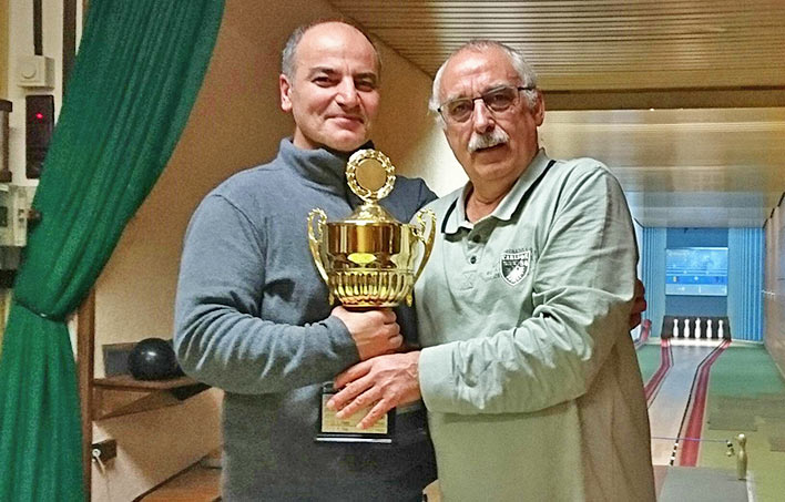 Uwe Rothstein, Vorsitzender der Kegelgesellschaft 'Strack Dur', berreicht den Siegerpokal an Ali Tensi