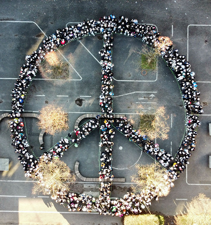Schlerinnen und Schler sowie das Kollegium der TOB Bielstein gruppierten sich auf dem Schulhof zum Friedenszeichen. Foto: Arlind Oseku